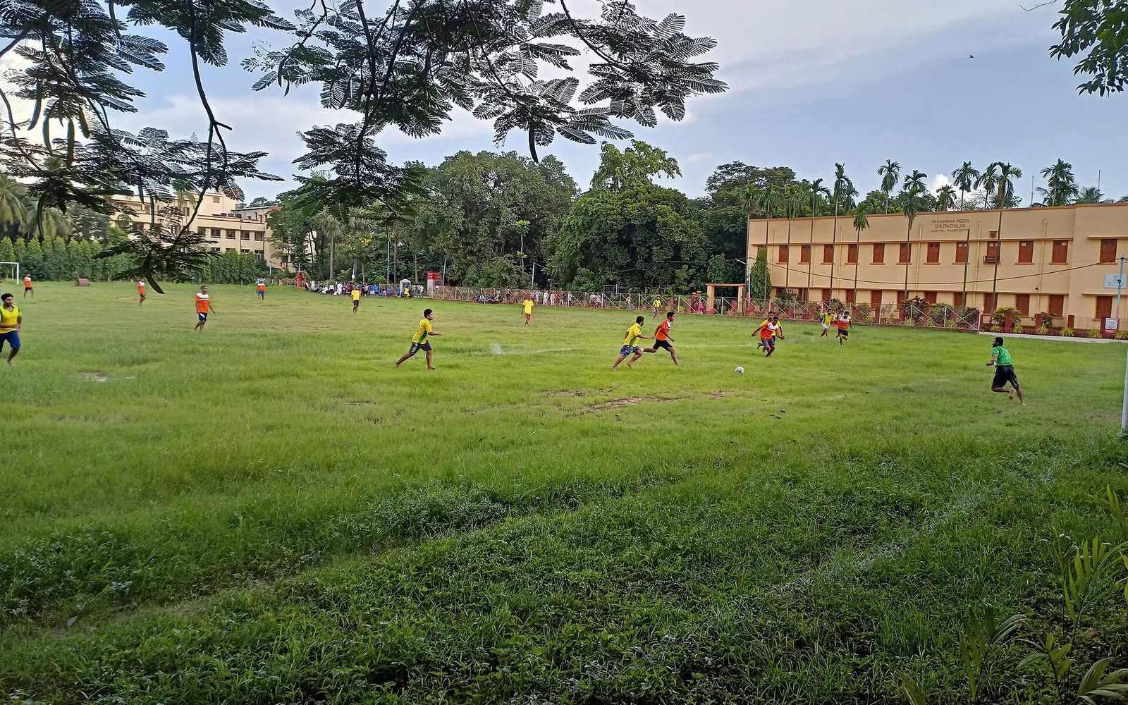 Students playing football together on a large grass field