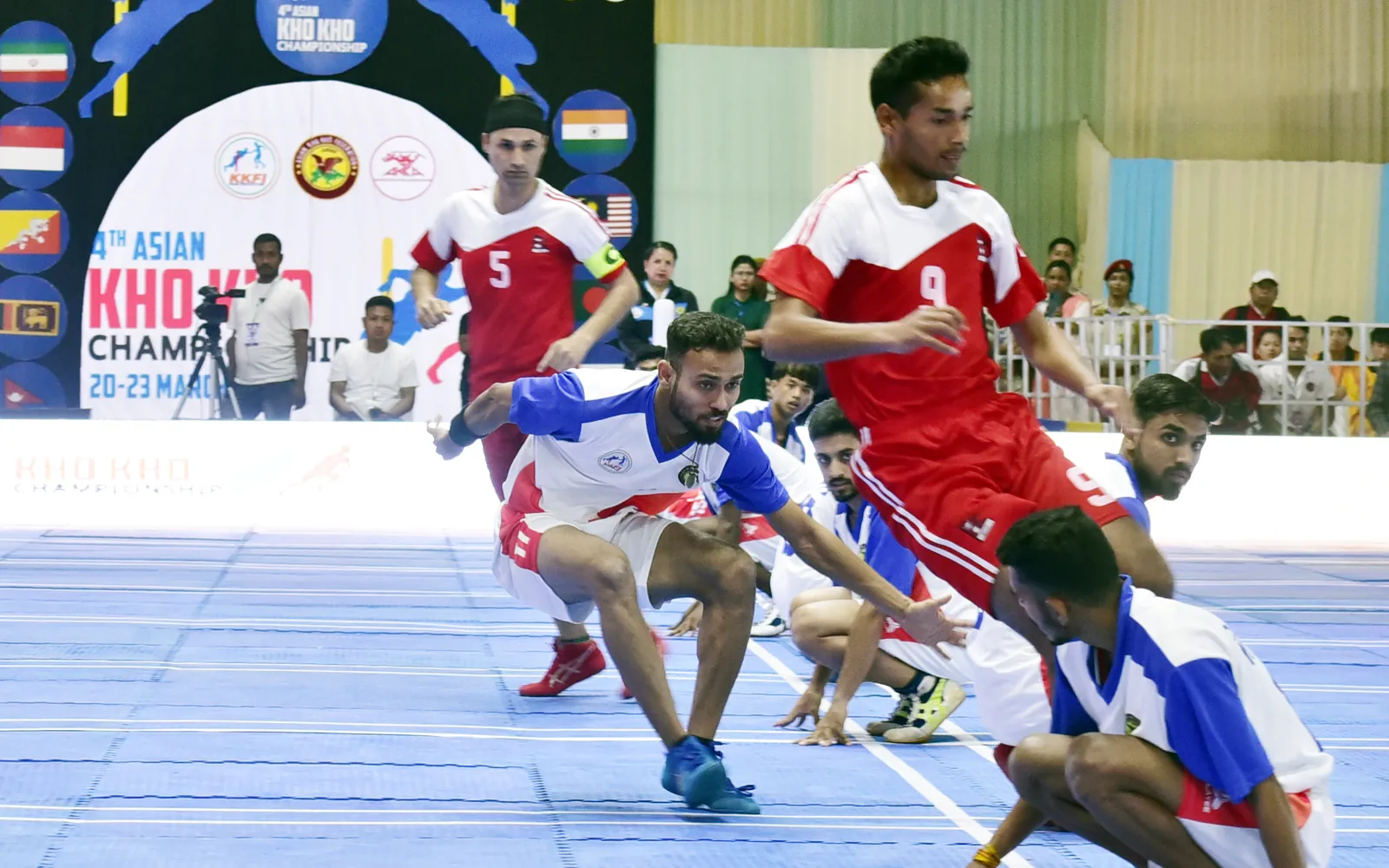 Players chasing and sitting in a line during a kho kho match at an international championship