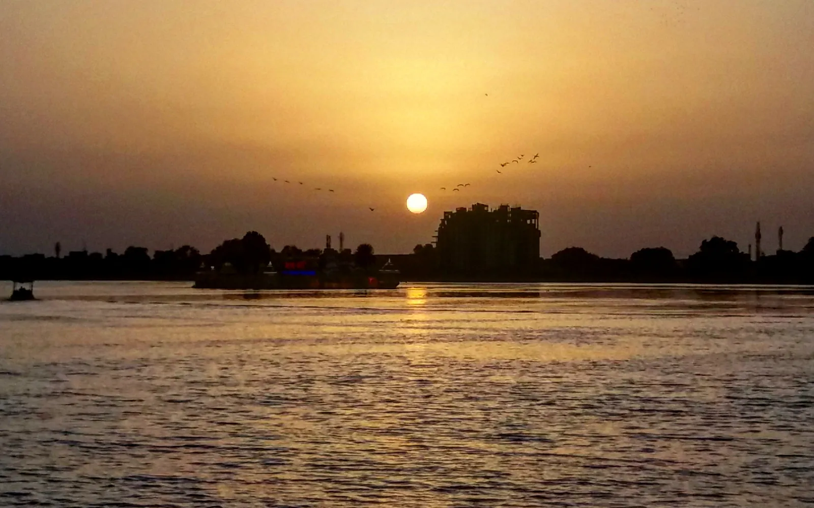 Sunset over Kishore Sagar lake in Kota with the city skyline in silhouette